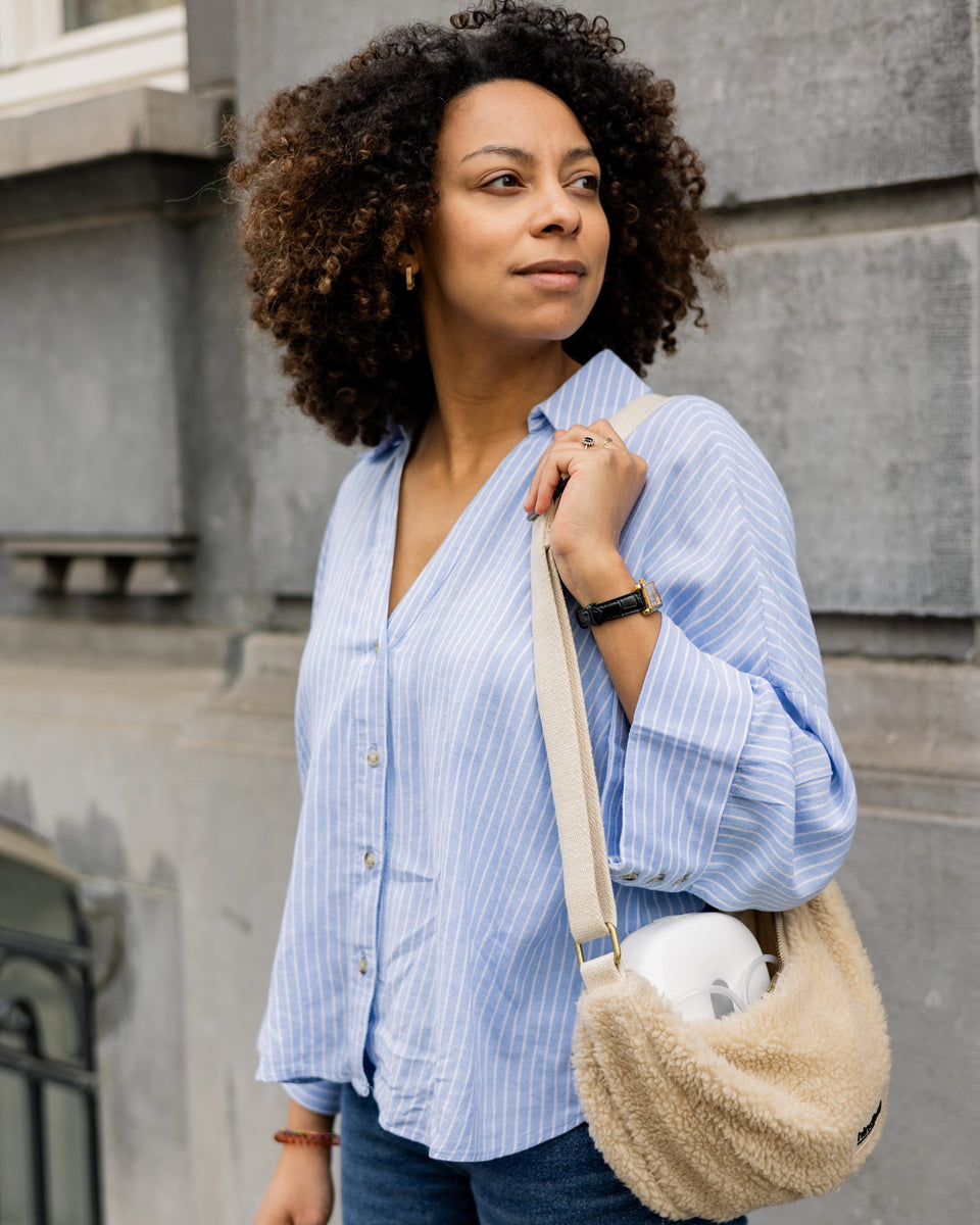 A mother walks through the city, the Lileo breast pump in a bag over her shoulder.